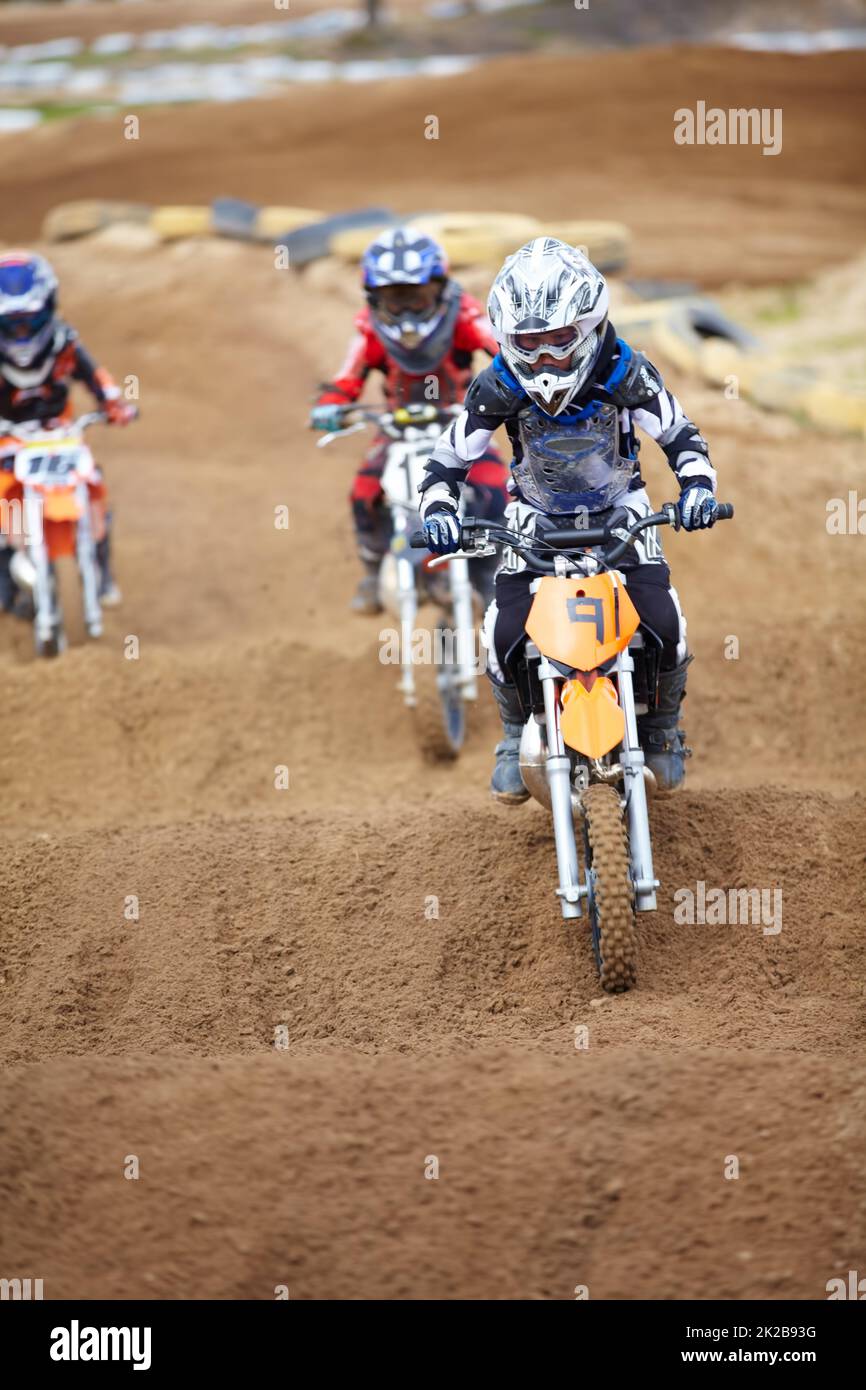 Its a tricky part of the track. Three motocross riders riding in close proximity to each other. Stock Photo
