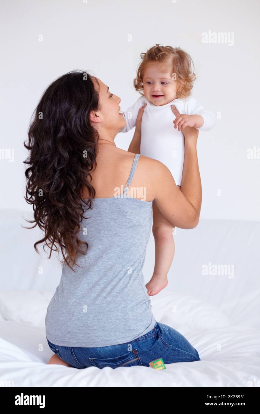 My gorgeous little angel. Rearview shot of a mother holding up her baby daughter. Stock Photo