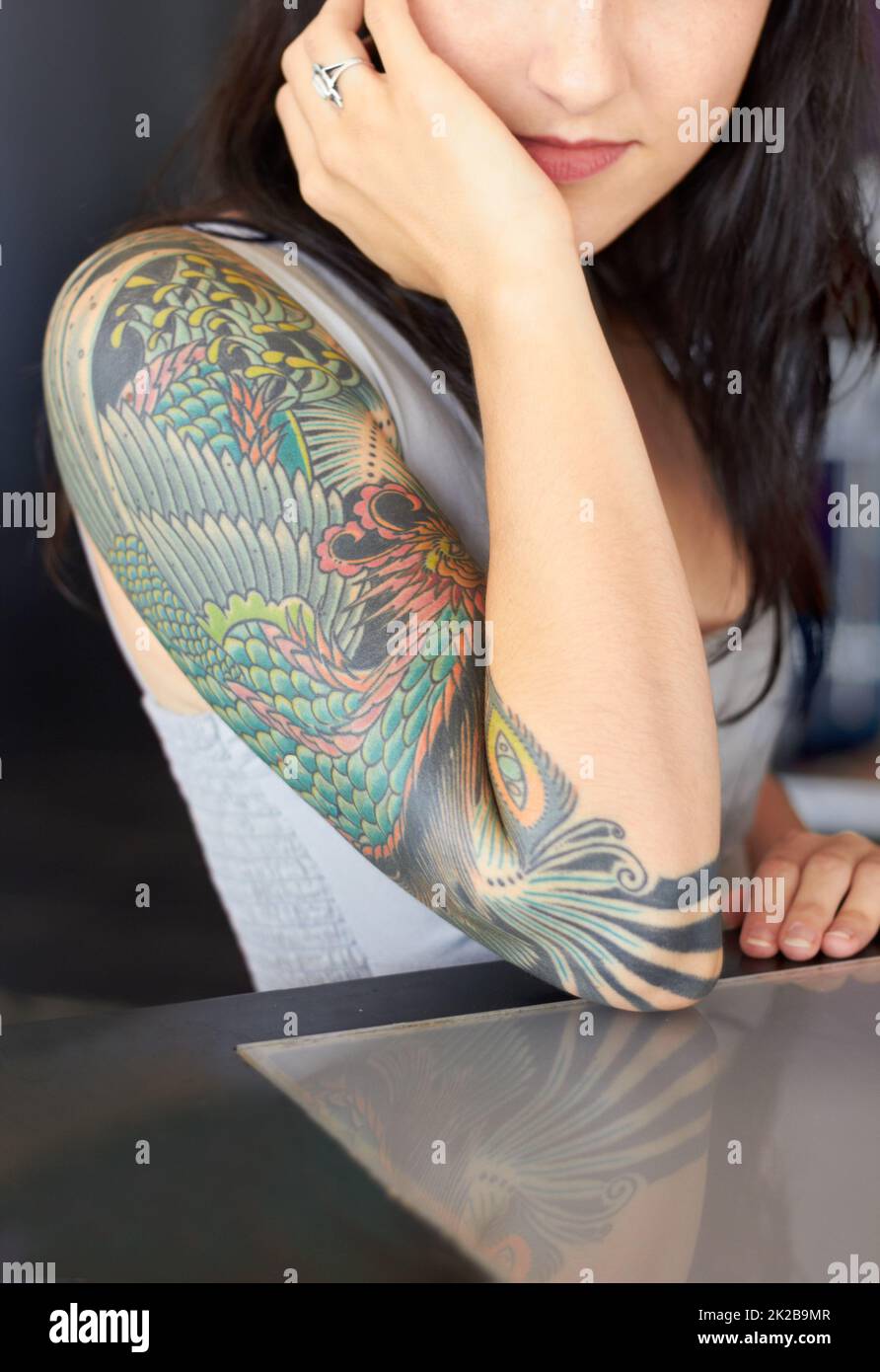 The beauty is in the detail. Cropped shot of a young tattoo artist showing off her half-sleeve tattoo. Stock Photo