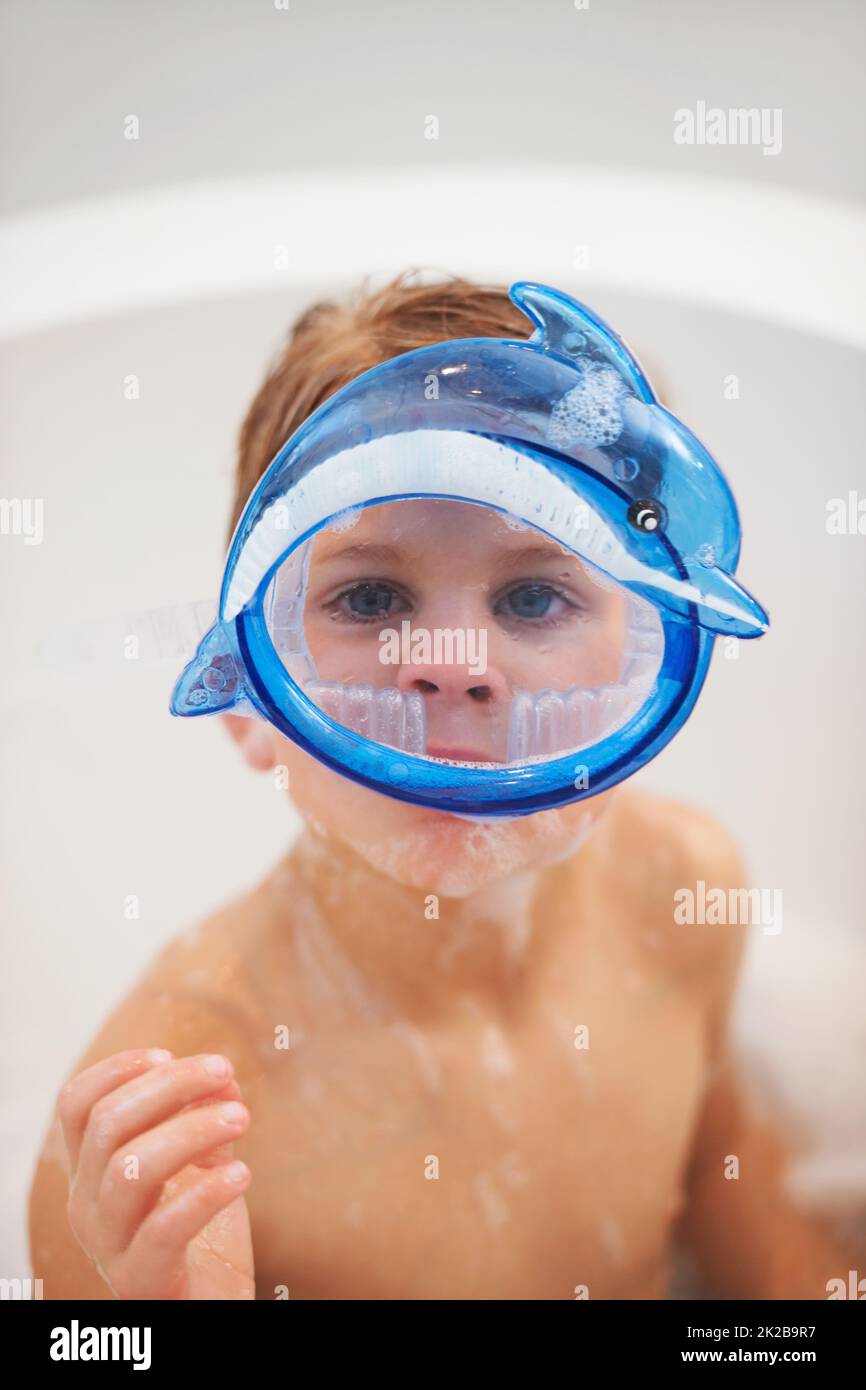 Bathtime is playtime. Portrait of a cute young boy wearing dolphin goggles in the bath. Stock Photo