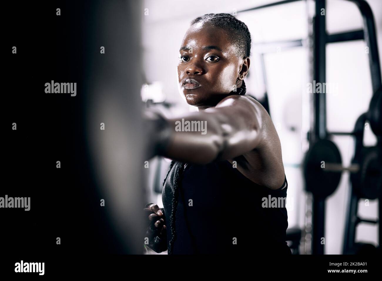 Striking with accuracy. Cropped shot of an attractive young female athlete working out on a boxing bag in the gym. Stock Photo