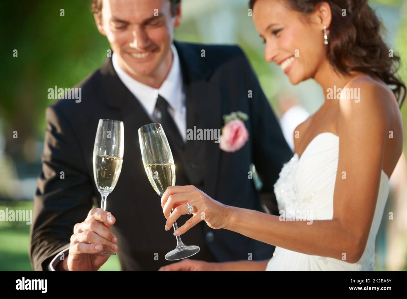 Heres to our romance. Cropped view of a young bride and groom standing together and toasting their marriage. Stock Photo
