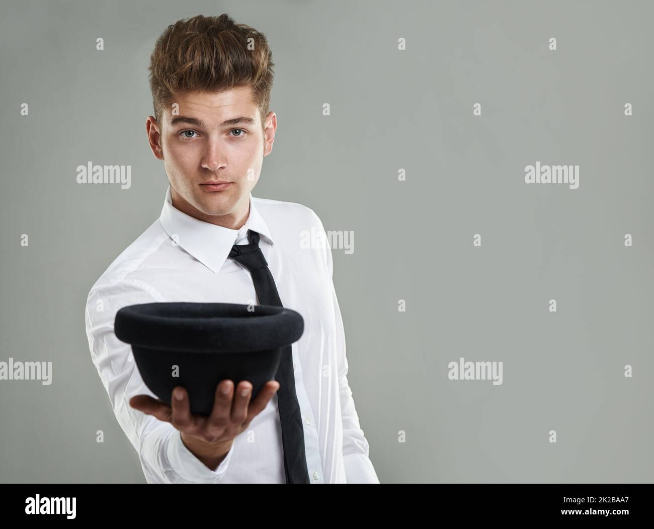 This hat completes my look. A young hipster holding his hat out while