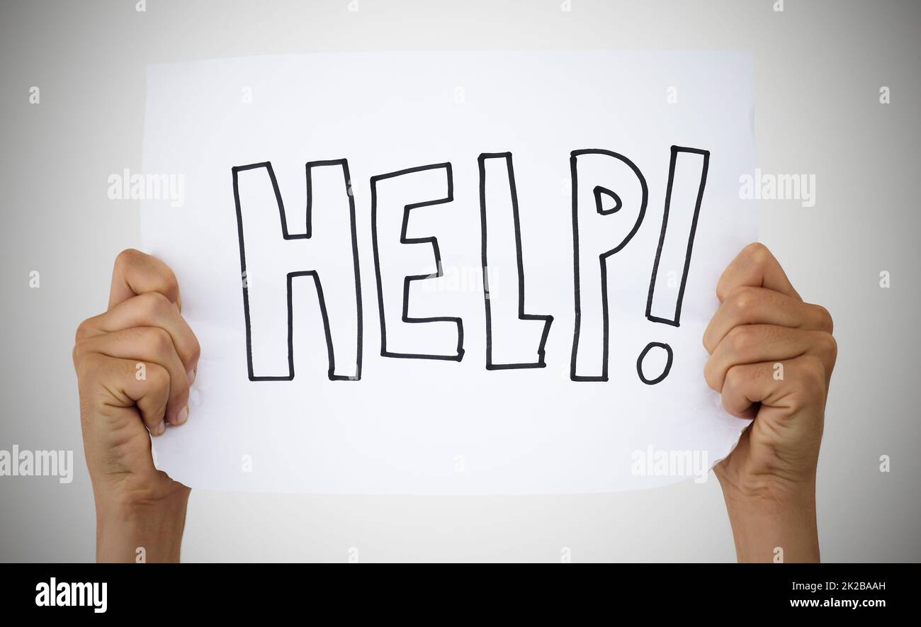 Asking for help is a sign of strength. Studio shot of an unrecognisable person holding up a sign that says help against a grey background. Stock Photo