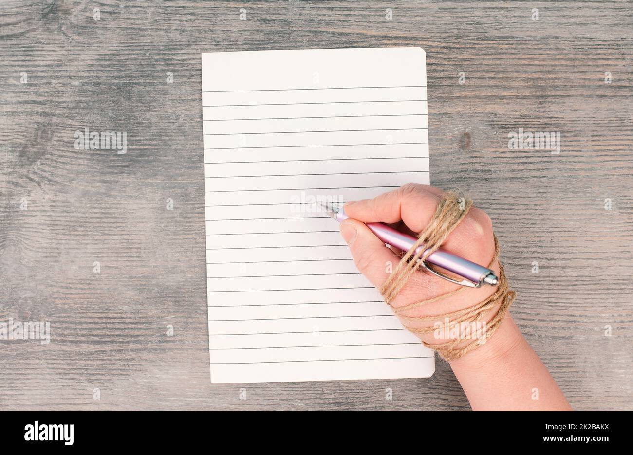 Cancel culture, chained hand with a pen, free press,freedom of speech, discrimination and censorship, new normal, empty paper with copy space Stock Photo