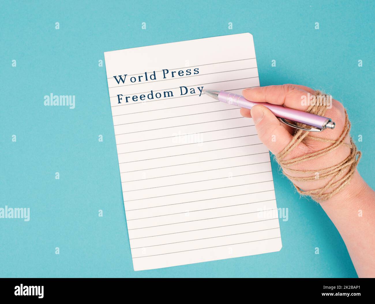 World Press Freedom Day is standing on a paper, hand with pen is chained, free speech, cancel culture, journalist writing Stock Photo