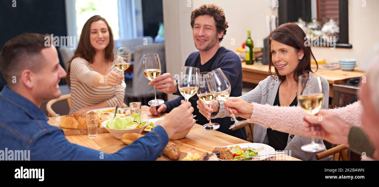Heres to family. Cropped shot of a family sharing a meal around the dinner table. Stock Photo