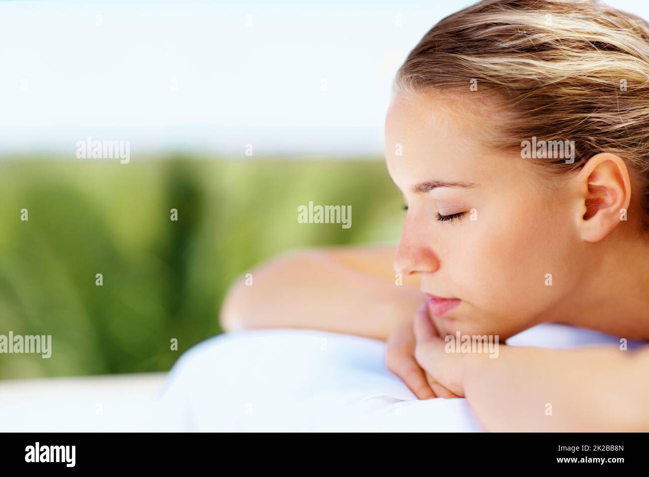 Side view of a relaxed female with eyes closed at a health spa. Profile view of a relaxed young woman with eyes closed at a health spa. Stock Photo