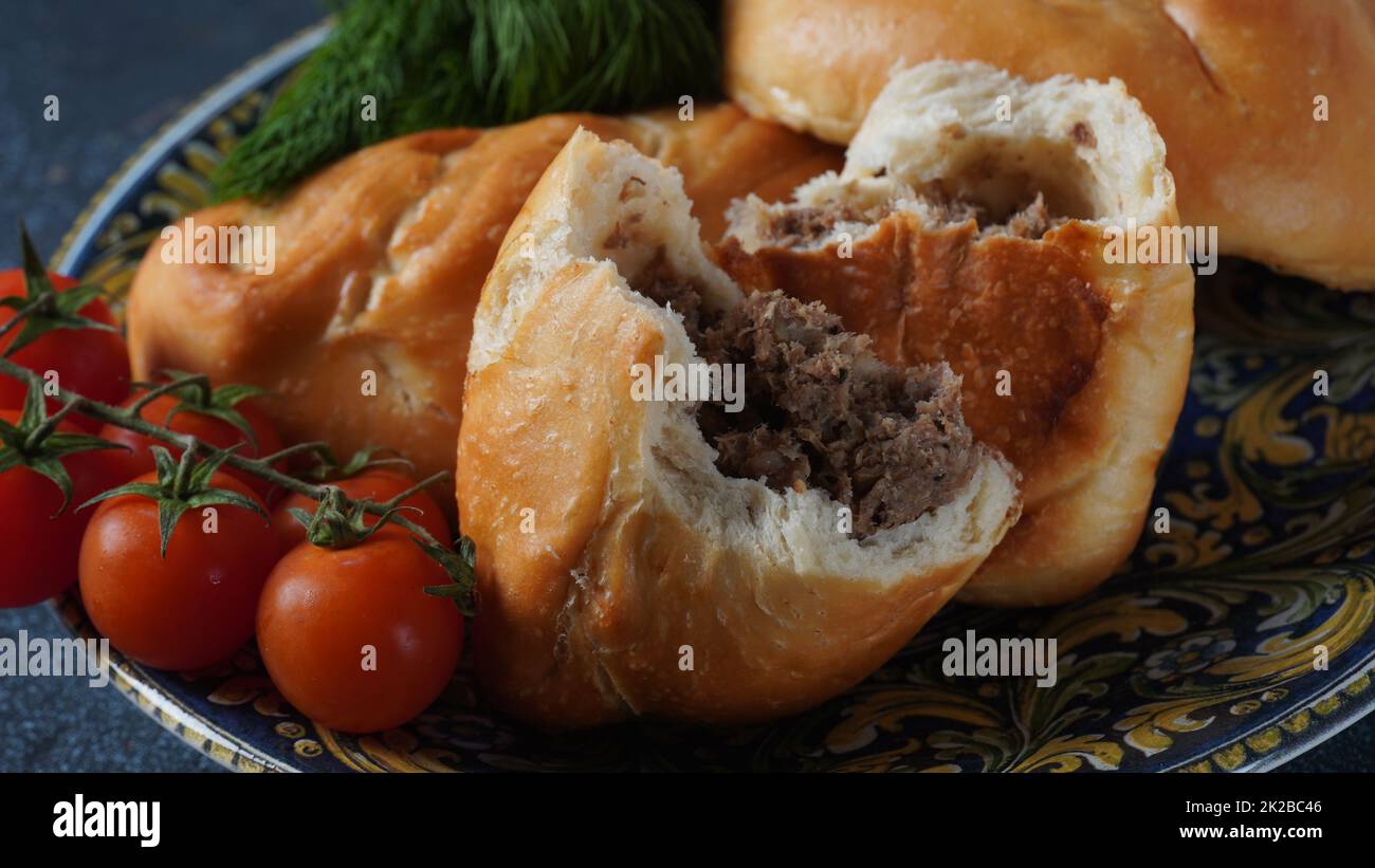 Ukrainian Patties (Pasties, Hot Cakes, Pirozhki, Pies) on a plate. Traditional homemade backed pies  with meat Stock Photo
