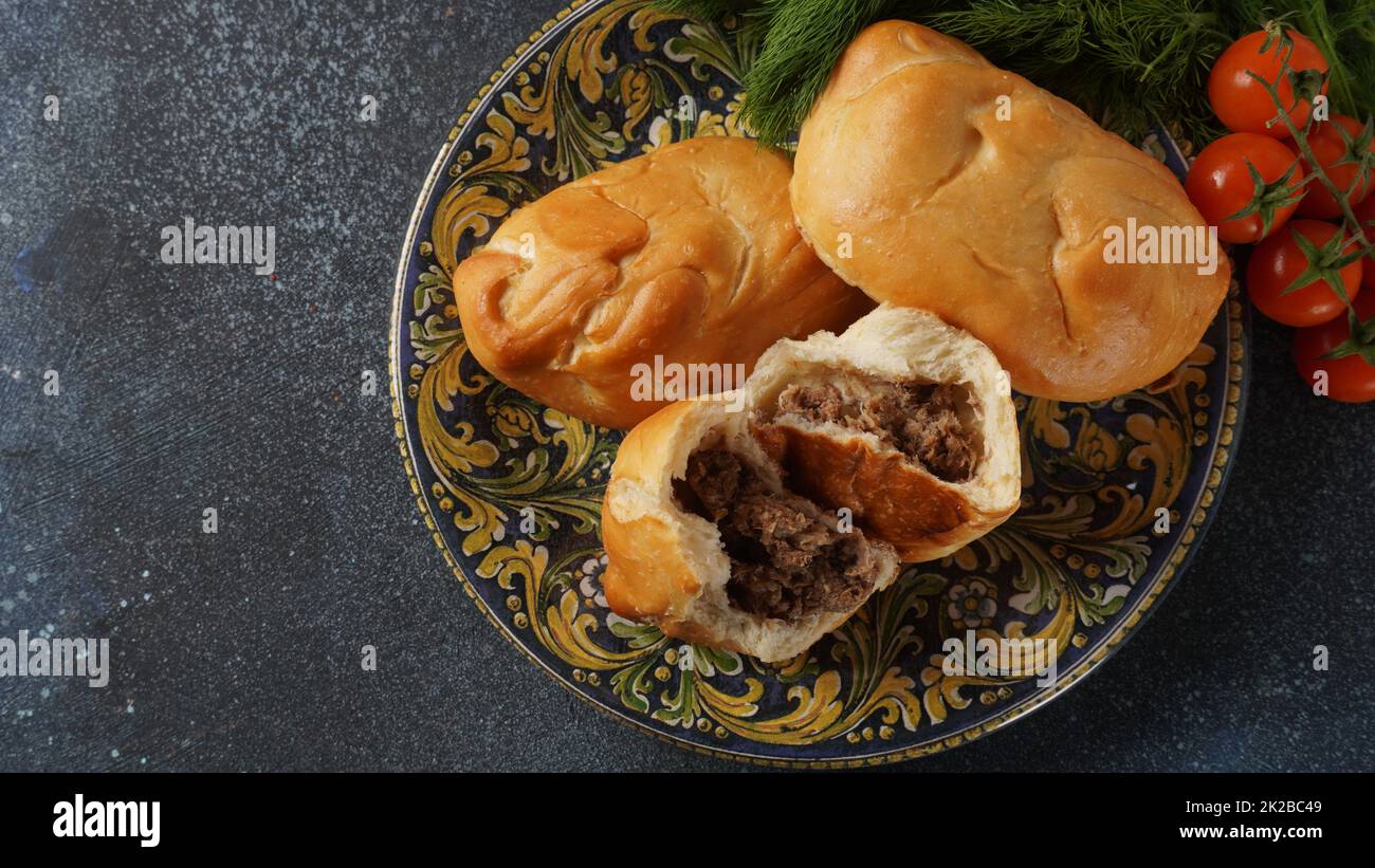 Ukrainian Patties (Pasties, Hot Cakes, Pirozhki, Pies) on a plate. Traditional homemade backed pies  with meat Stock Photo