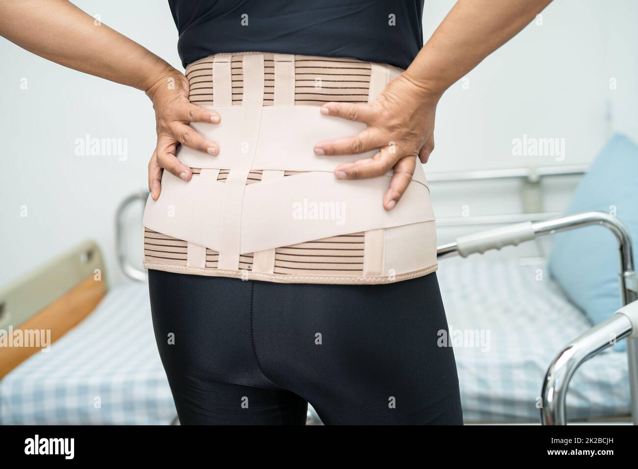 Asian lady patient wearing back pain support belt for orthopedic lumbar ...