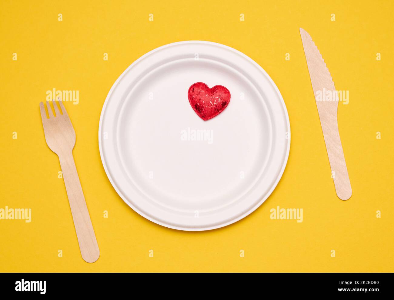 white plates on a yellow background. Recyclable garbage, rejection of plastic, top view Stock Photo