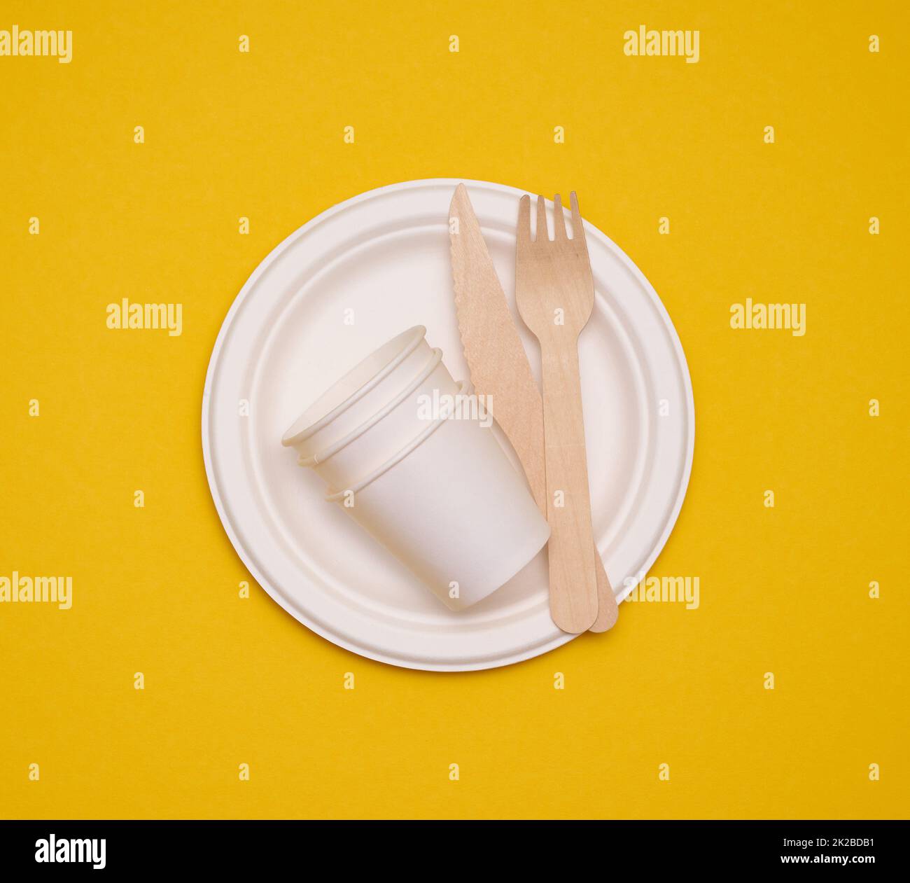 paper cups and plates on a yellow background. Recyclable garbage, rejection of plastic Stock Photo