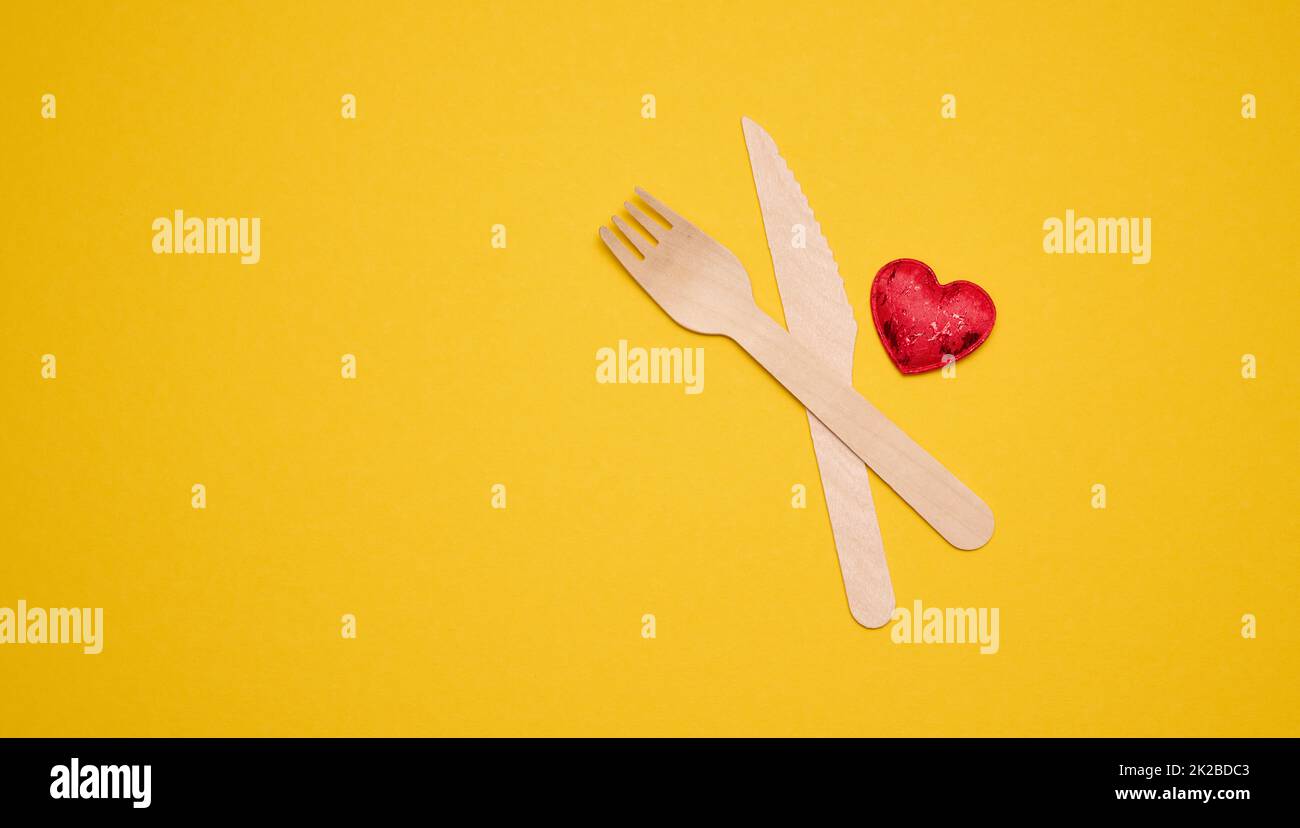 disposable fork and knife on a yellow background, eco utensils. Zero Waste Stock Photo