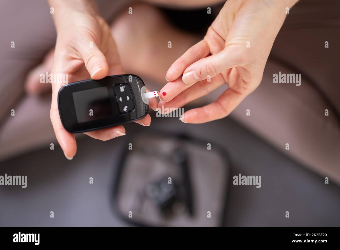 Blood sugar testing at home. Woman checking blood sugar level by