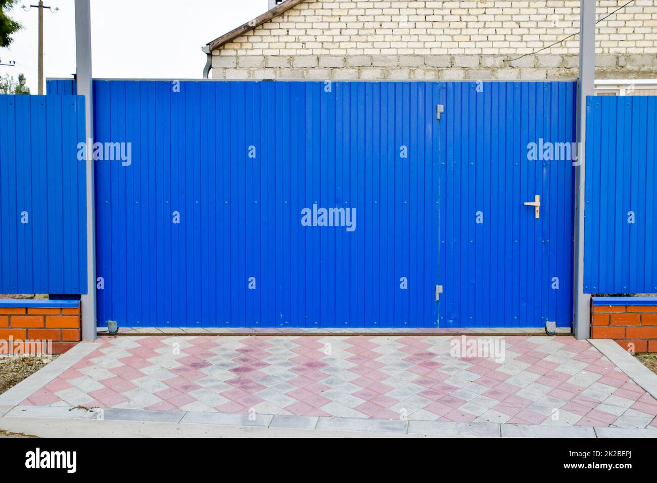 Fence and gate from sheets of blue corrugated metal. Stock Photo