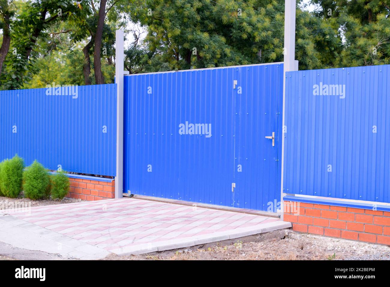 Fence and gate from sheets of blue corrugated metal Stock Photo - Alamy