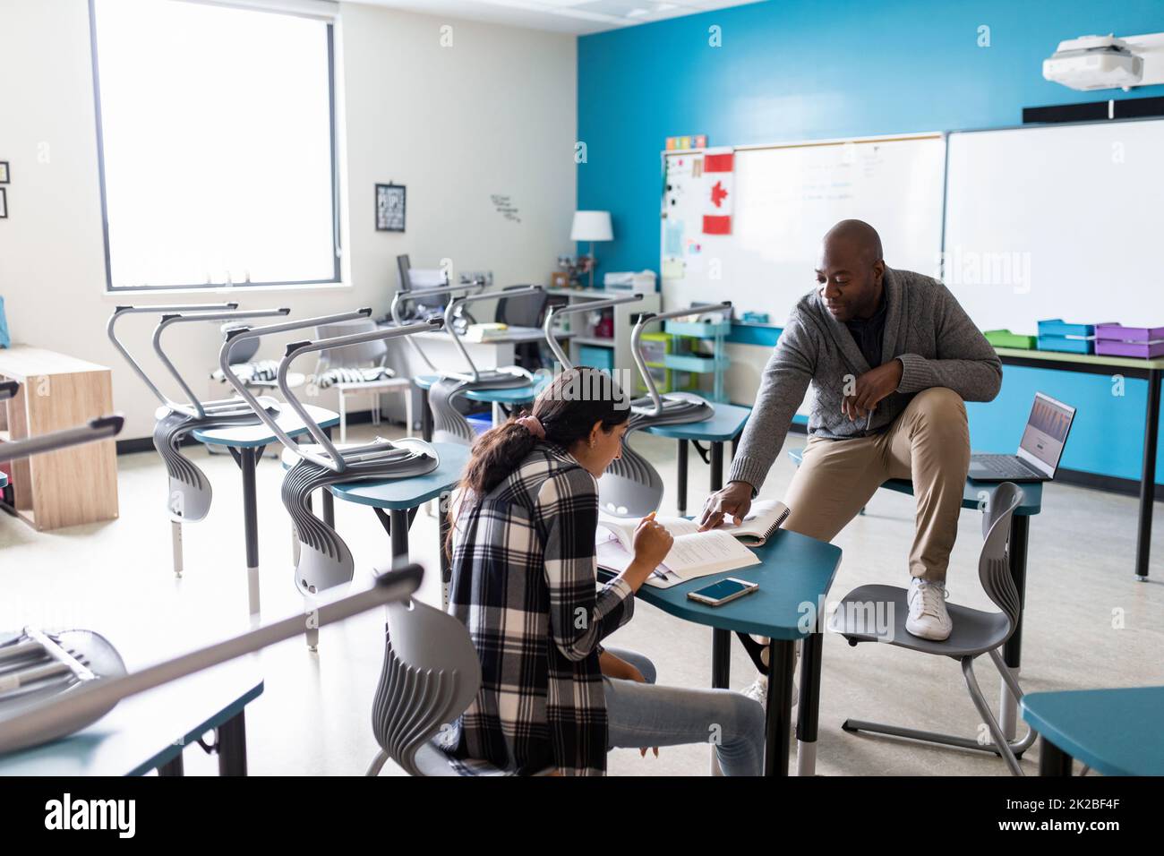 Teacher and student talking in class Stock Photo - Alamy
