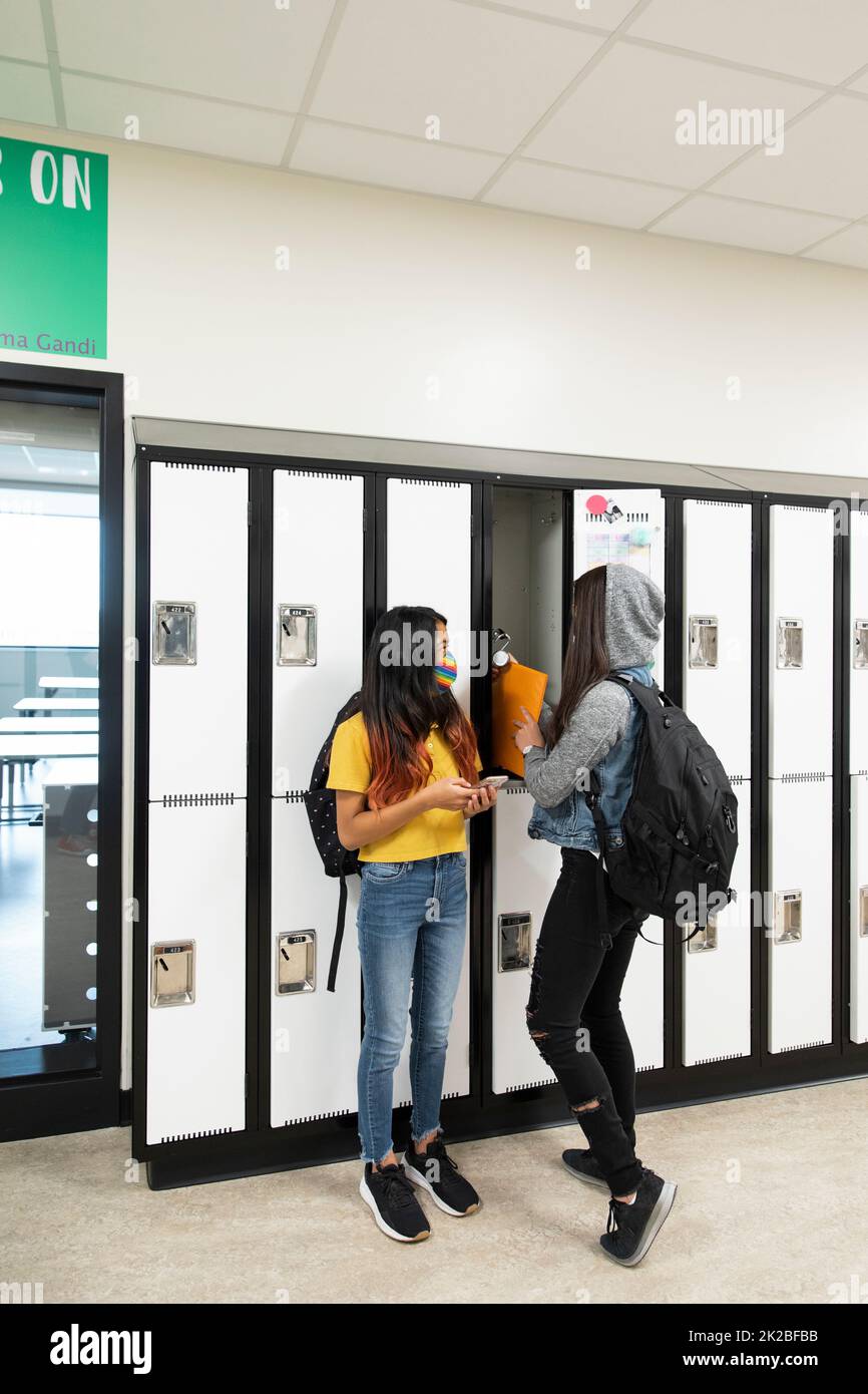 Students by lockers wearing masks Stock Photo