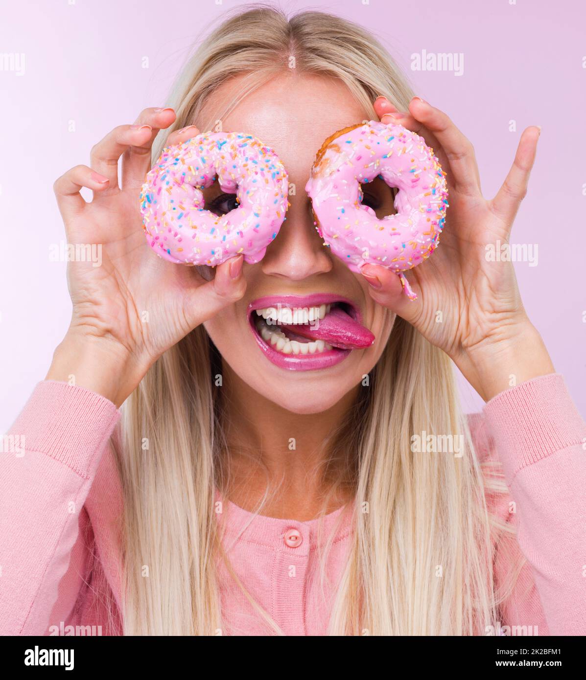 Shes going doNUTS. a woman holding donuts in front of her eyes while