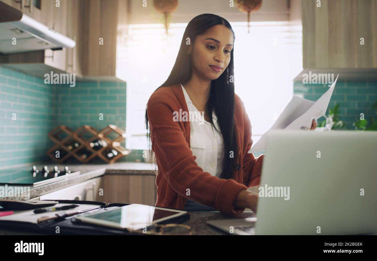 I like getting a productive start to my day. Shot of a young businesswoman working from home using her laptop at home. Stock Photo