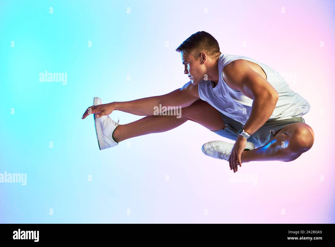 Reaching new heights. Studio shot of a handsome young male athlete jumping against a multi-coloured background. Stock Photo