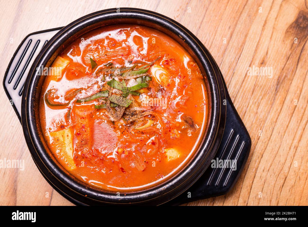 Korean traditional Kimchi Jjigae soup in bowl in the restaurant Stock
