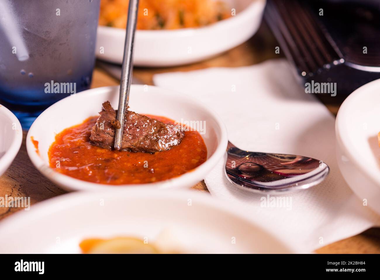 Sliced pork using chopsticks dipping in spicy sauce Japanese food style