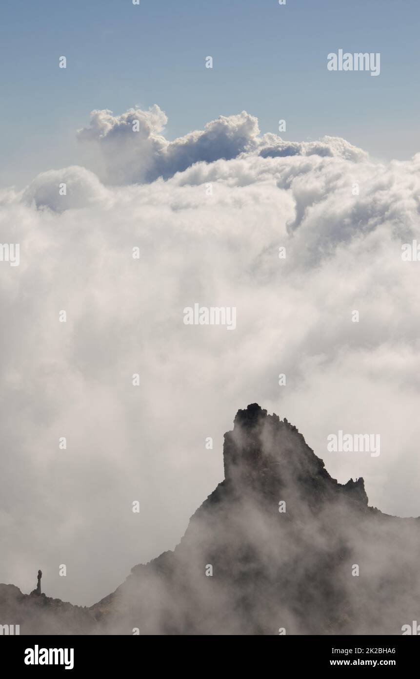 Cliff, sea of clouds and smoke plume from a volcanic eruption. Stock Photo