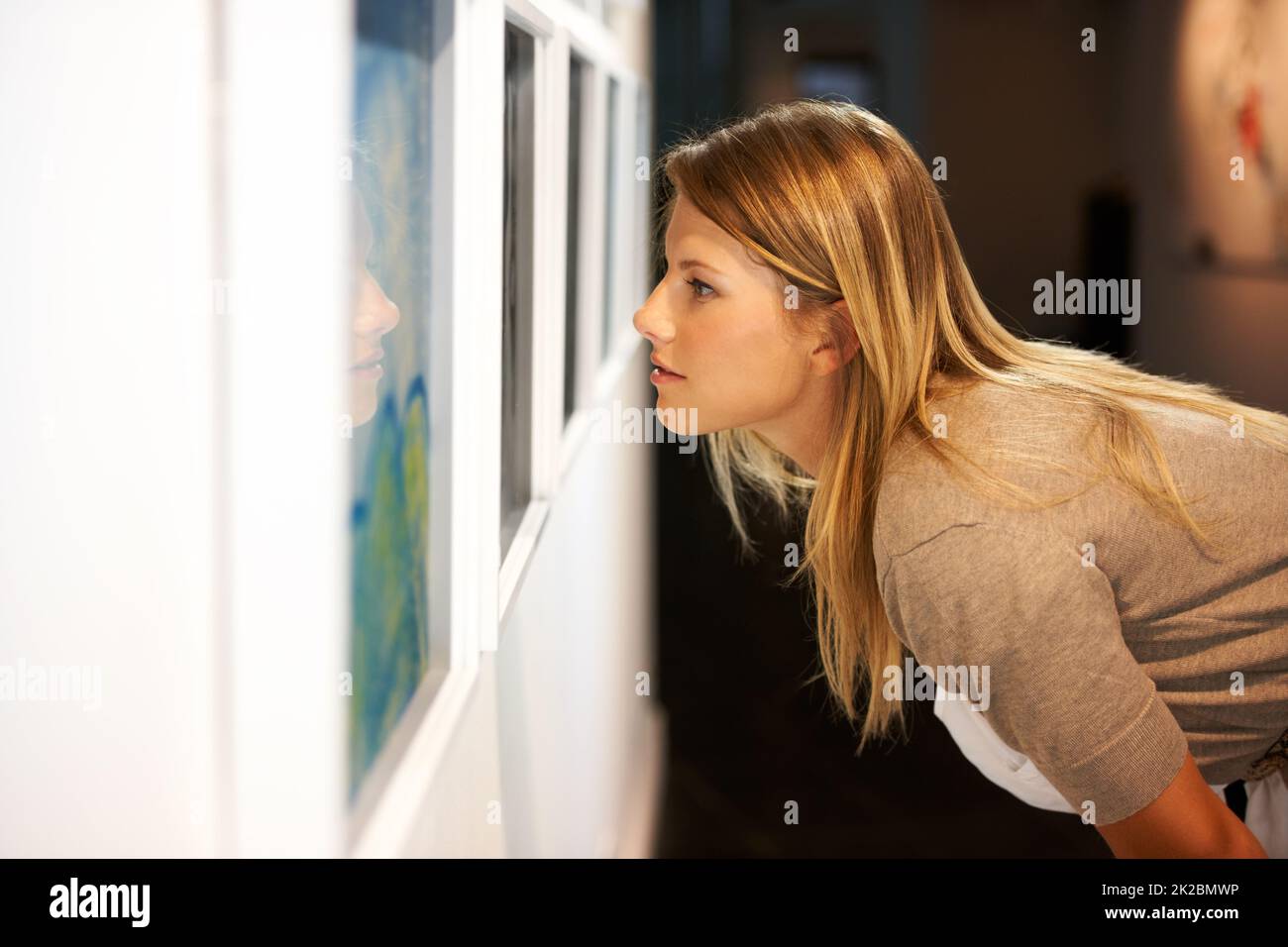 Taking in a century of art. Shot of a young woman looking at paintings in a gallery Stock Photo