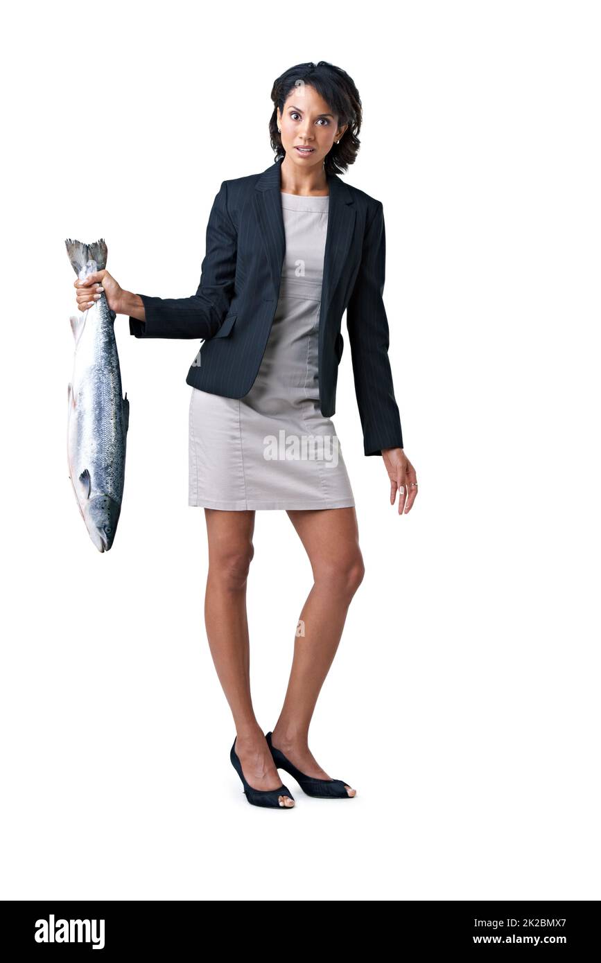 Somethings fishy here.... - Suspicious business deals. Studio shot of a businesswoman holding a dead fish against a white background. Stock Photo