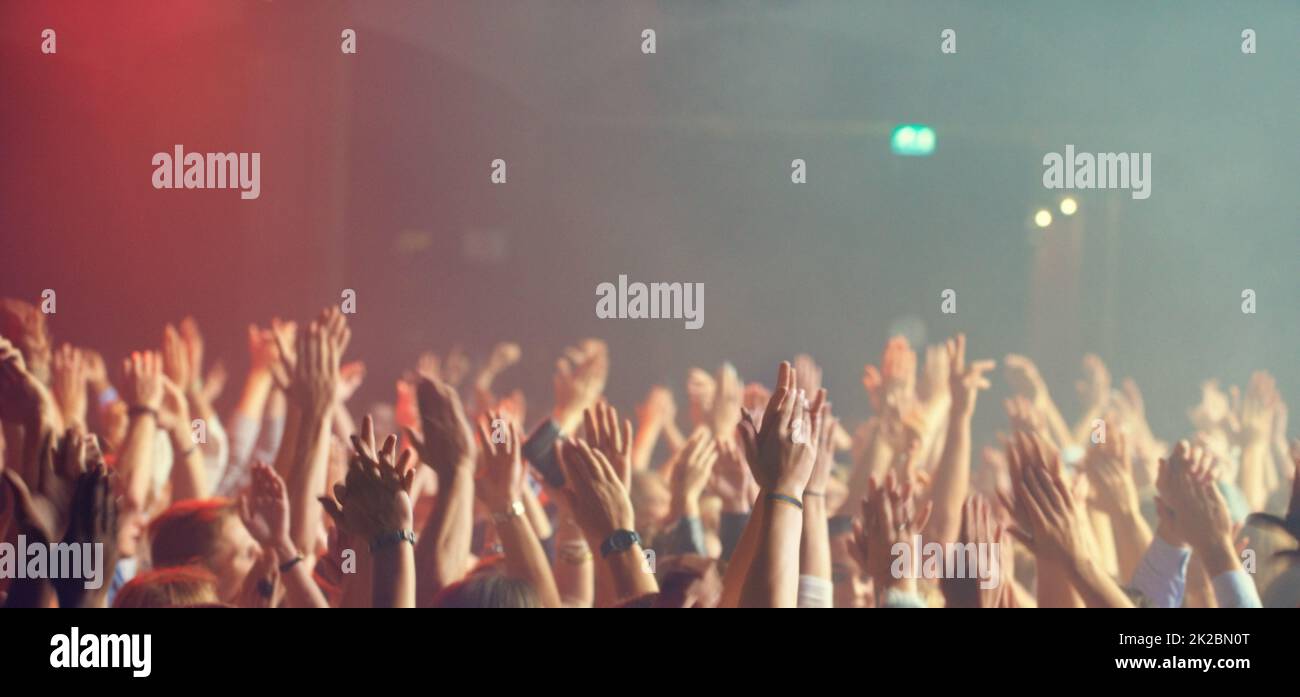 A crowd of people celebrating and partying with their hands in the air to an awesome band. This concert was created for the sole purpose of this photo shoot, featuring 300 models and 3 live bands. All people in this shoot are model released. Stock Photo