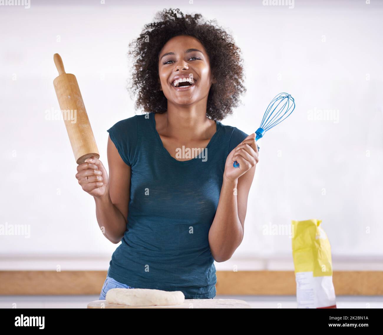 Which one is called the rolling pin. Young woman preparing dough in her