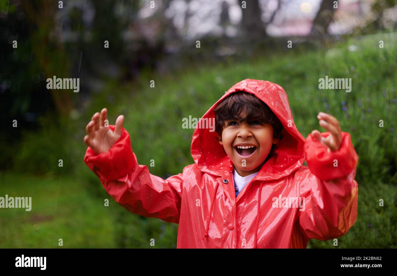 Shot of a little boy wearing a raincoat playing outside Stock Photo Alamy