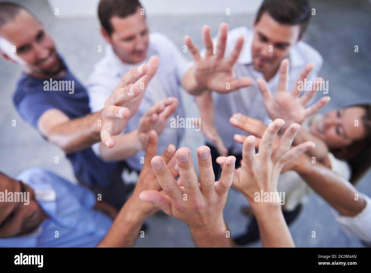 Reaching for their goals. Shot of a group of coworkers raising their