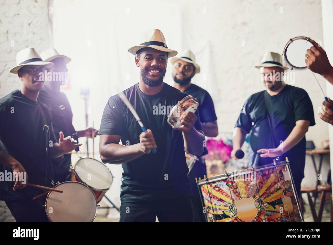 Their beats bring so much energy into the room. Shot of a group of musical performers playing drums together. Stock Photo