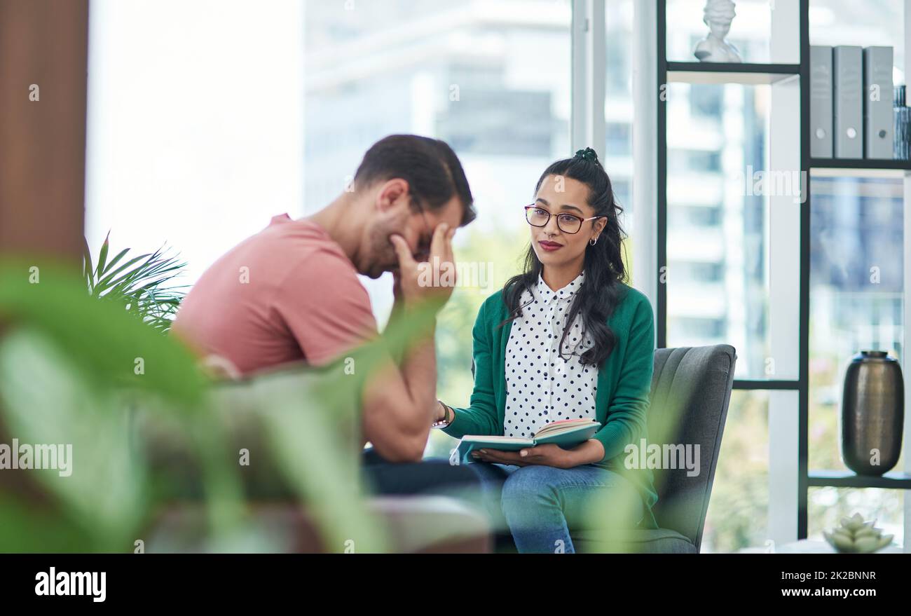 Failure hurts, but with help it doesnt have to. Shot of a young man crying while having a discussion with a woman in a modern office. Stock Photo