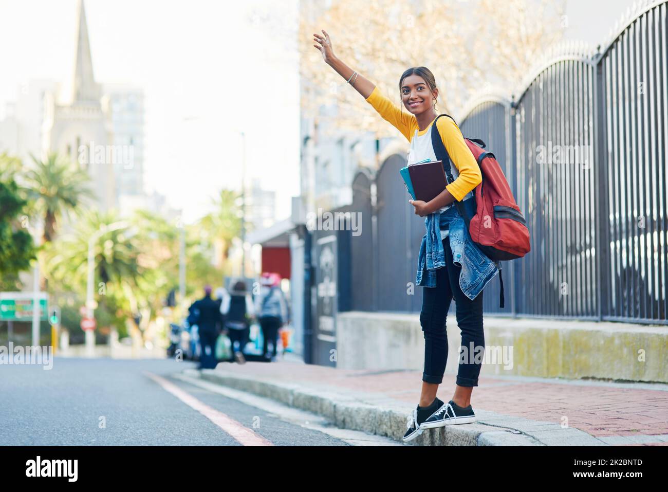 Got to catch a cab on my way to college. Shot of a young female student commuting to college in the city. Stock Photo