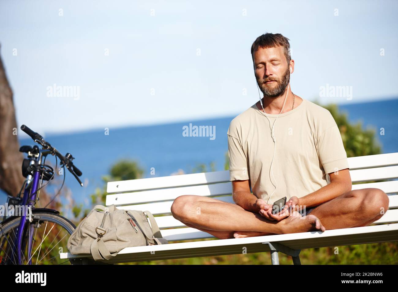 He cycled to his place of calm. Shot of a mature man listening to music while doing a relaxation exercise outdoors. Stock Photo