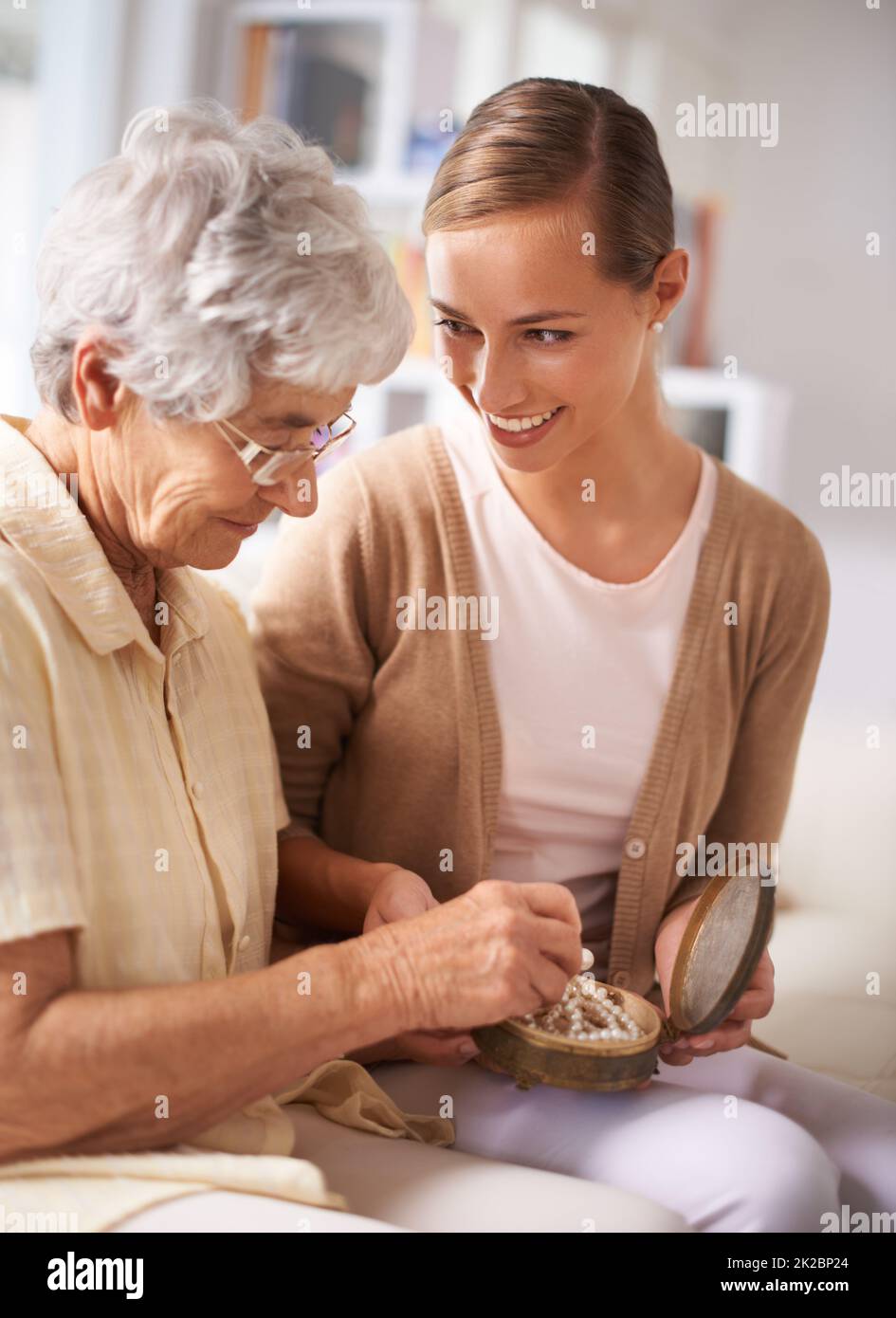 This has been in our family for generations. Cropped shot of a senior woman giving her daughter a pearl necklace. Stock Photo