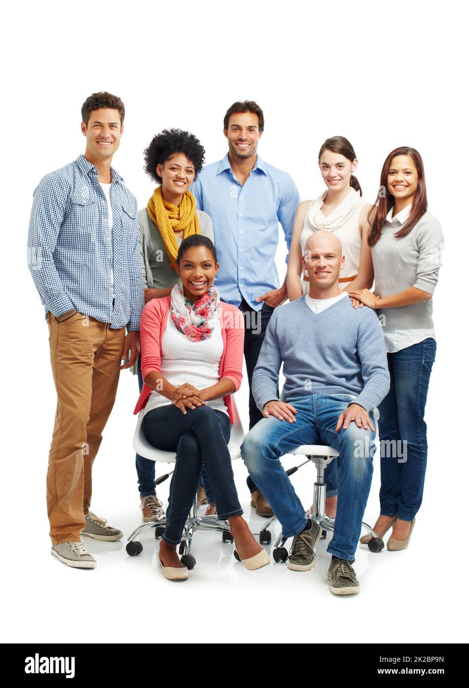 Theyre a smiling group. Smiling group of casual young adults together against a white background. Stock Photo