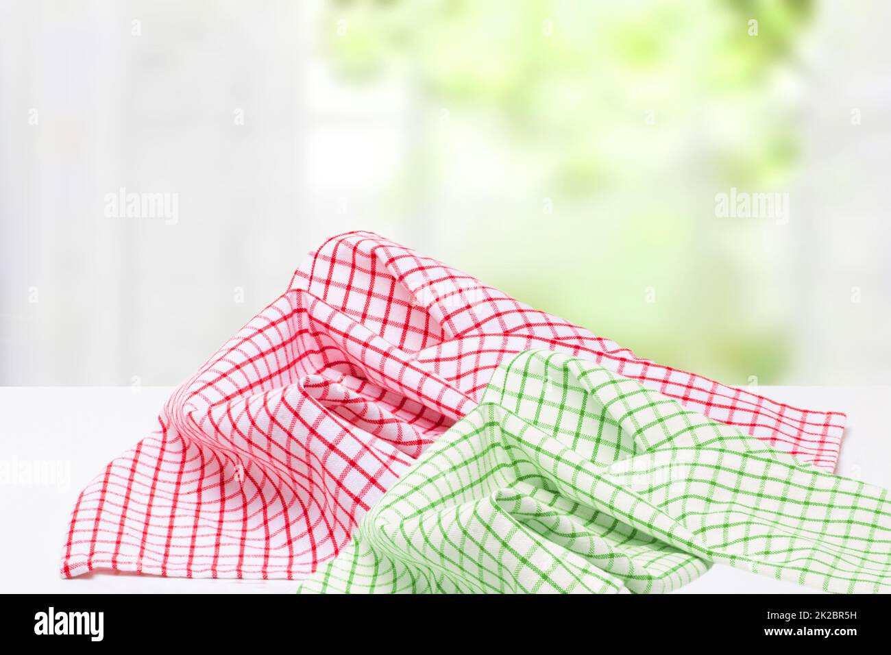 Empty desk table with red and green checkered tablecloth over abstract