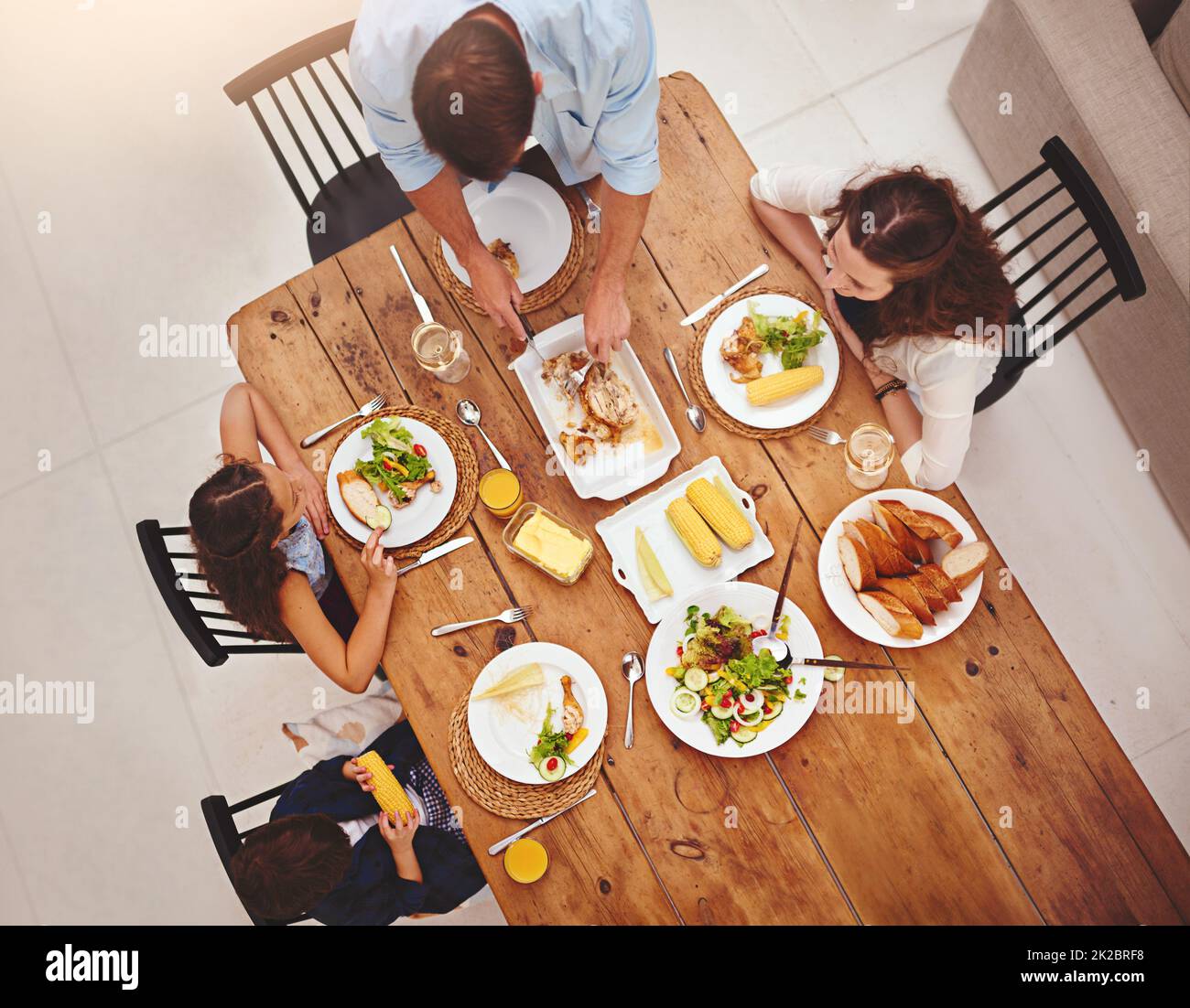 Family and food is one great recipe of love. High angle shot of a family eating homemade food around the dining room table. Stock Photo