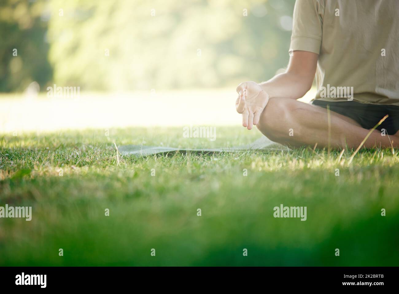 For body stress release. Cropped shot of a man sitting in the lotus position on the grass. Stock Photo