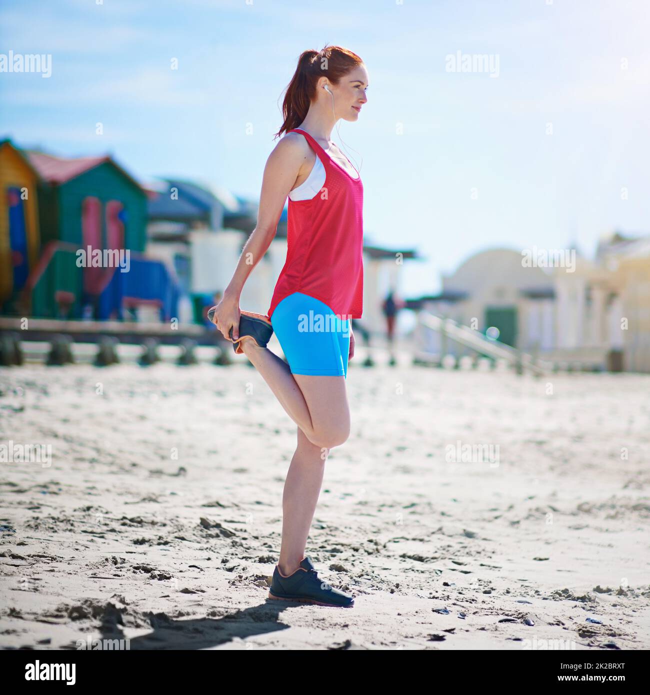Getting those muscles ready for a workout. Full length shot of a young woman stretching before a work out on the beach. Stock Photo