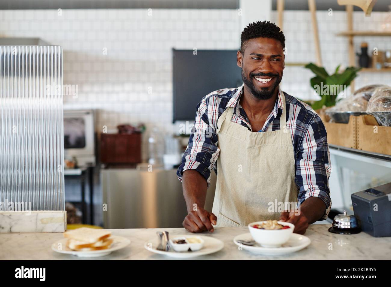 Breakfast - the most important meal of the day. Cropped shot of a handsome young man working in a cafe. Stock Photo