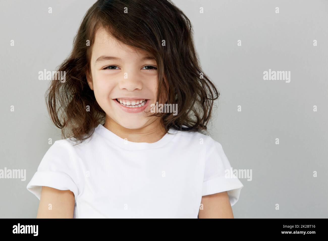 Sweet smiling. Portrait of a smiling little boy against a grey background. Stock Photo