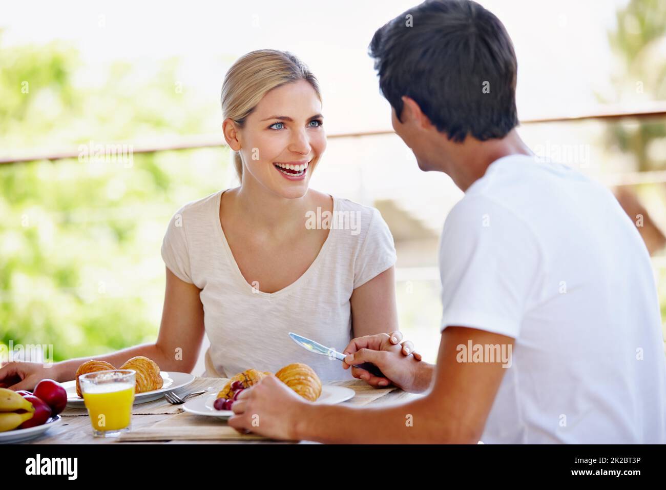 Enjoying their stay at the bed and breakfast. Shot of a happy young couple eating breakfast together on the patio at home. Stock Photo