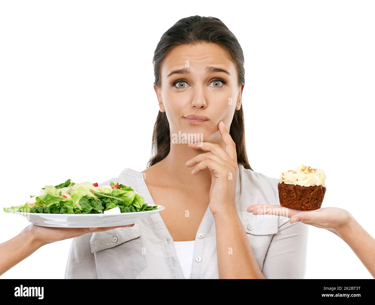 Should I or not. Studio shot of a young woman choosing between a healthy and unhealthy diet. Stock Photo