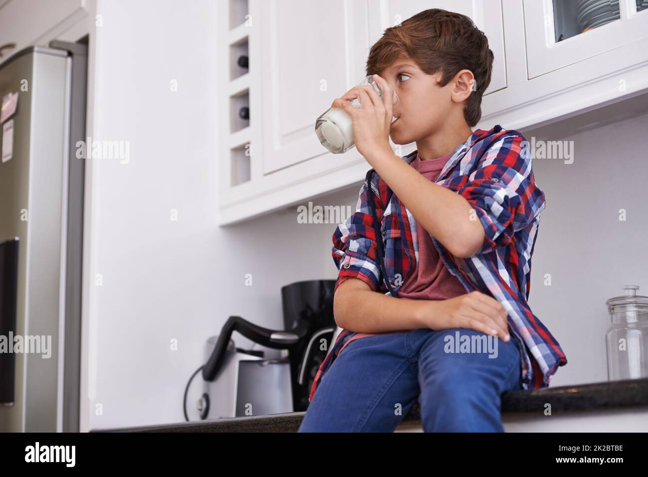 Enjoying his daily glass of milk. A young boy drinking a glass of milk. Stock Photo